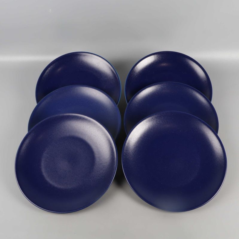 Sex mörkblå tallrikar utplacerade med ovansidan upp