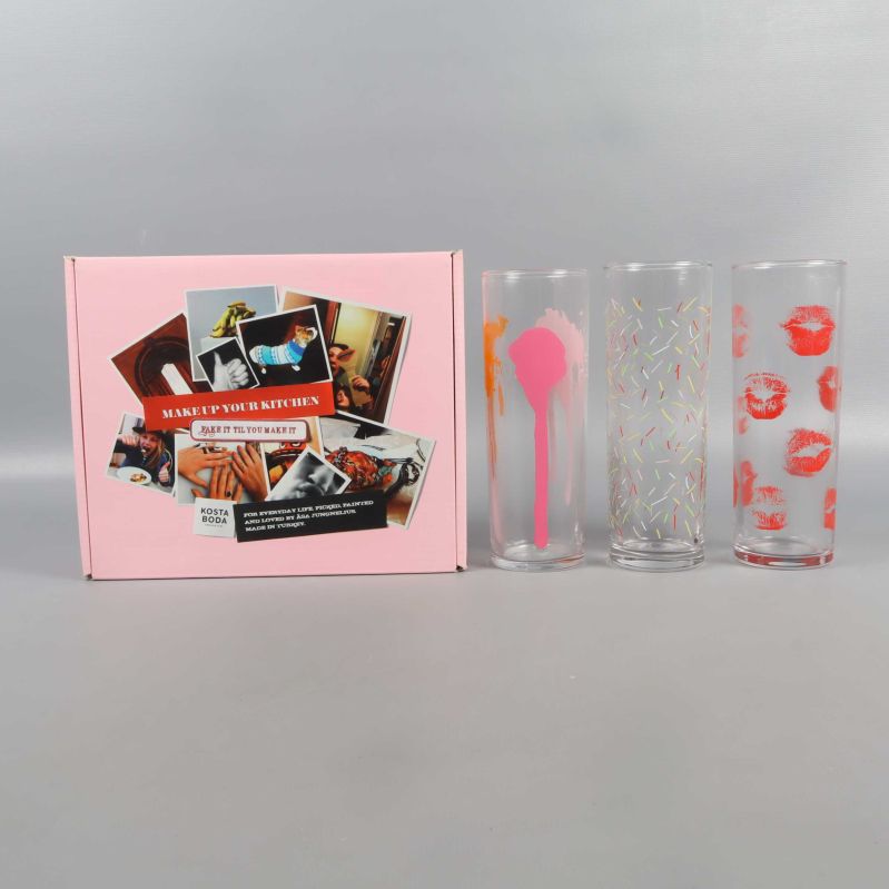 Tre färgglada highballglas och rosa kartong