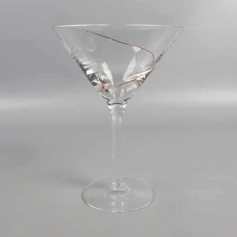 Ett cocktailglas med tydlig spiralformad gulddetalj