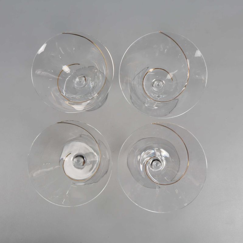 Fyra cocktailglas fotograferade ovanifrån med spiral i guld