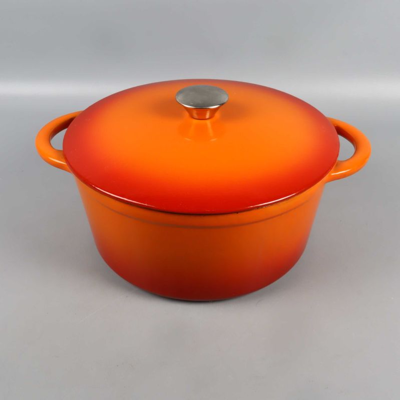 Helgjuten orange gryta med lock och två handtag framifrån