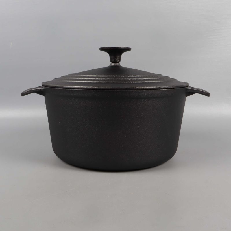 Framsidan av svart gjutjärnsgryta med lock