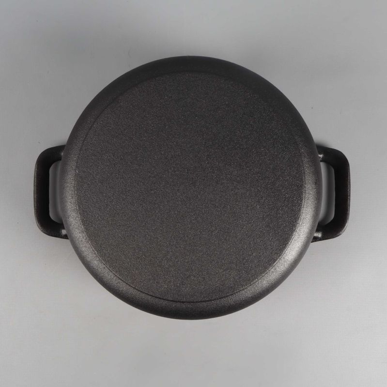 Undersida av rund gjutjärnsgryta med handtag