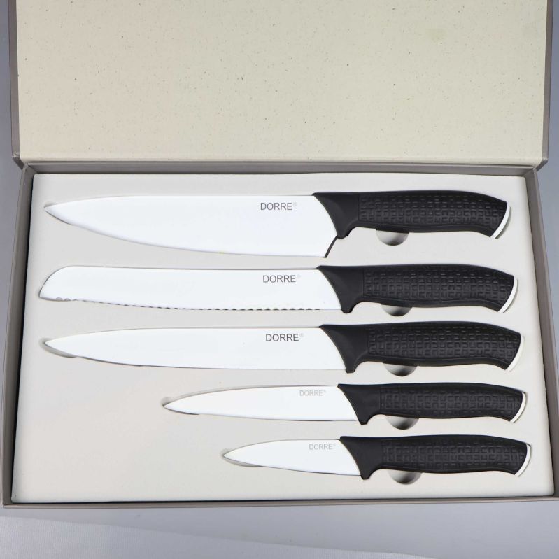 Närbild på fem knivar med svarta handtag liggande i ask