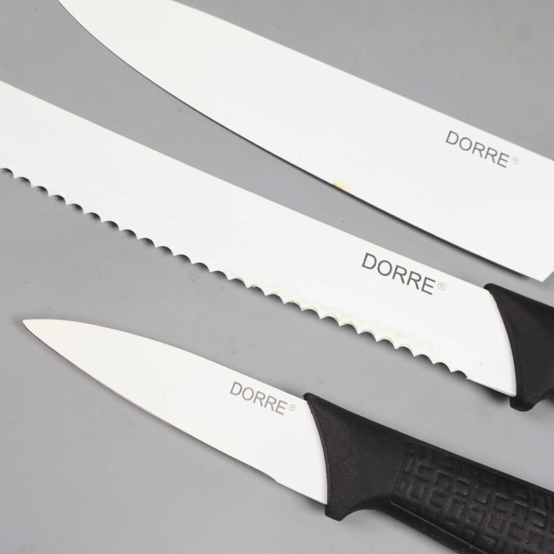 Närbild på tre knivar med vita blad och svarta handtag