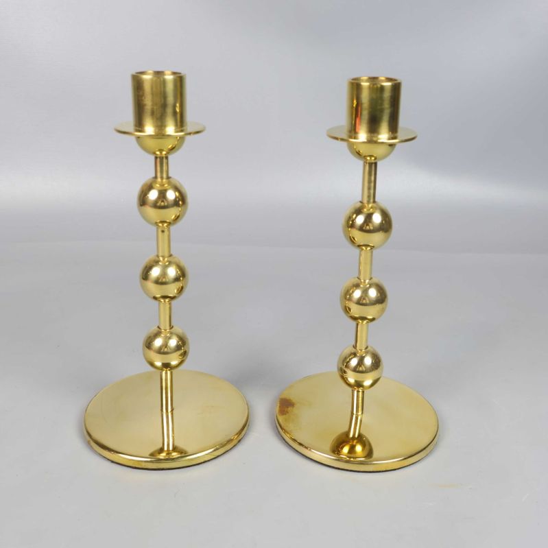 Två blanka mässingsljusstakar fotograferade ovanifrån