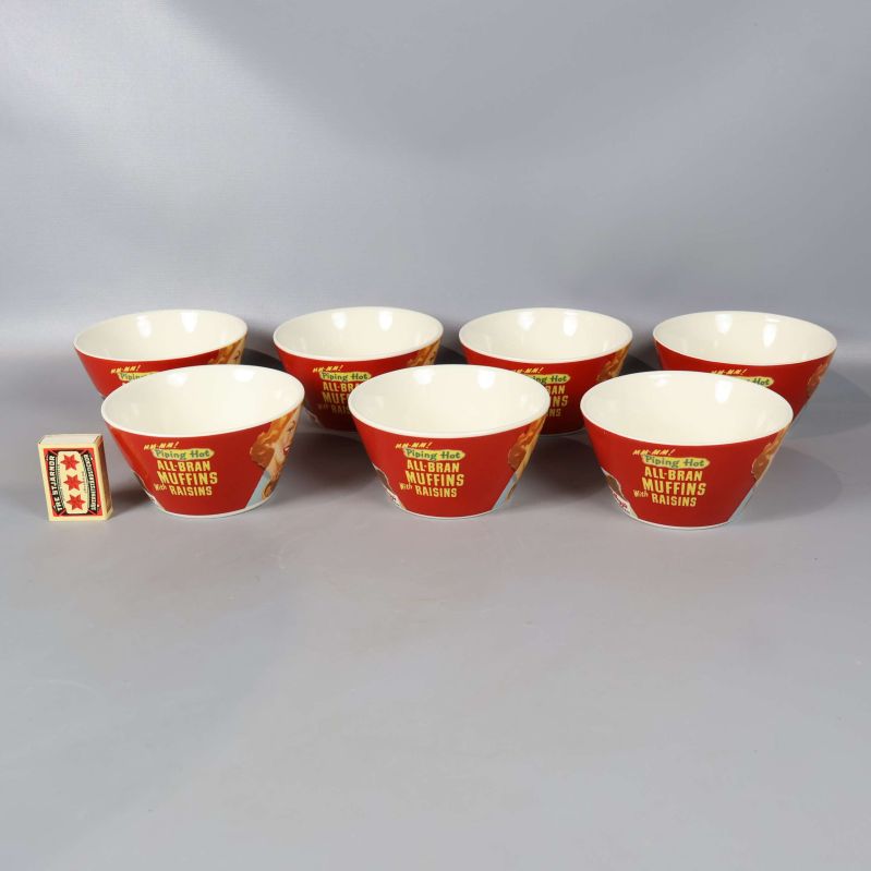 Baksidan av sju skålar med retroreklam och tändsticksask för storleksreferens