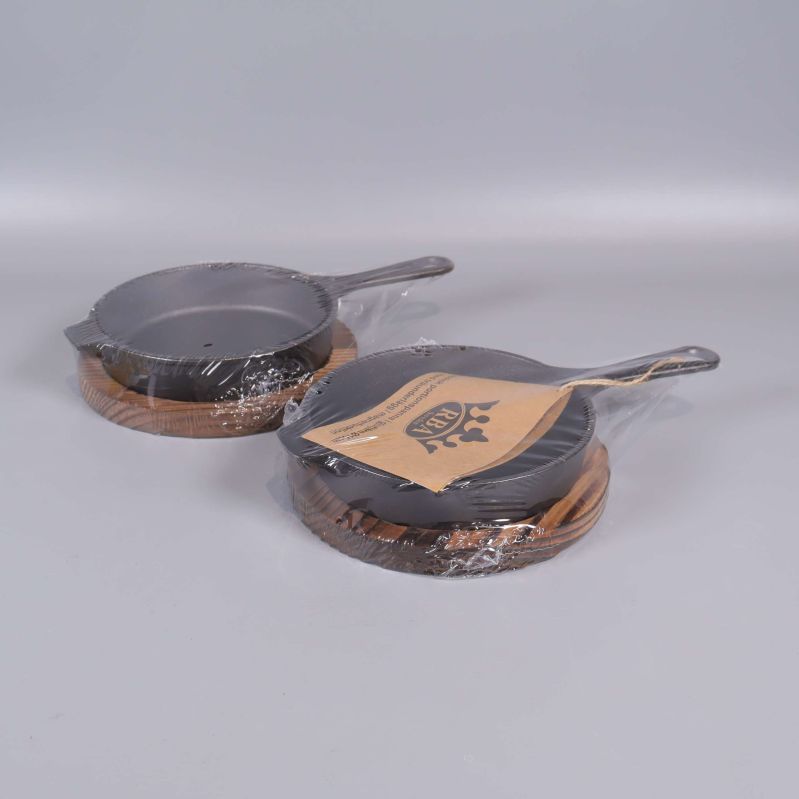 Två portionspannor placerade på träunderlägg med förpackning 