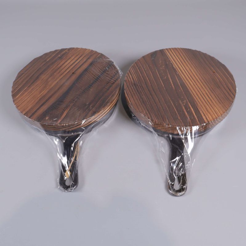 Botten på två portionspannor med runda träunderlägg