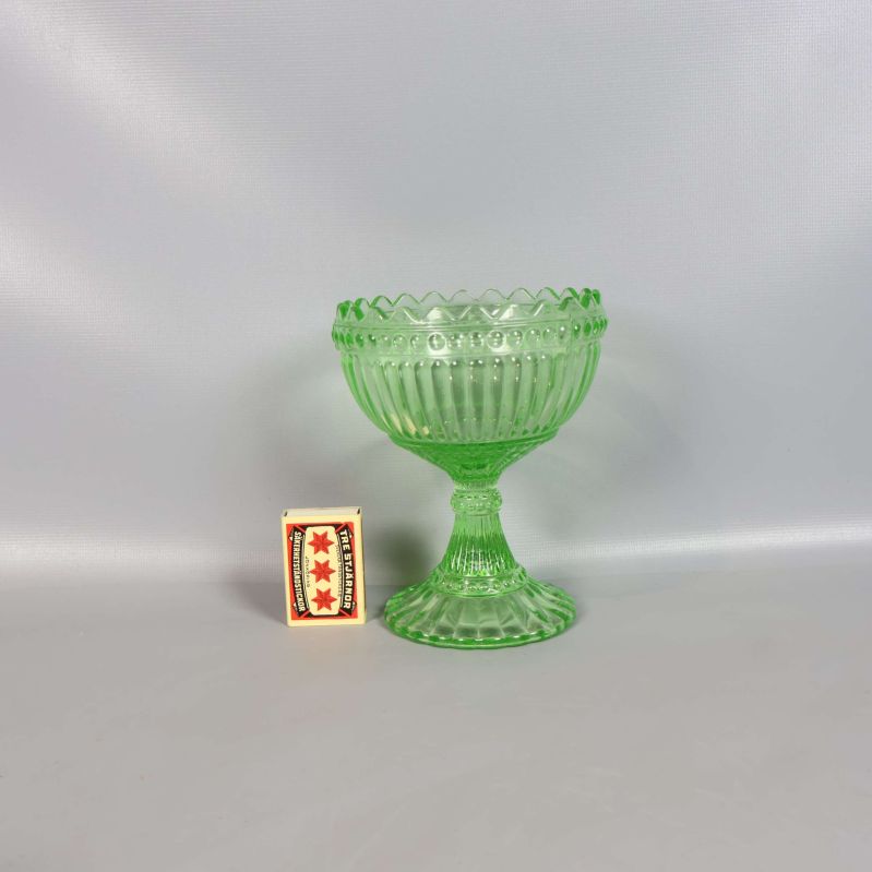 Grön glasskål jämte tändsticksask, visar storlek