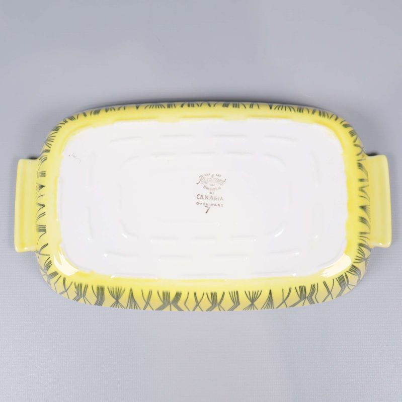 Undersida av ugnsform med stämpel och gul kant