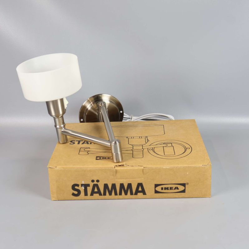 Vägglampa monterad ovanpå sin originalkartong från IKEA