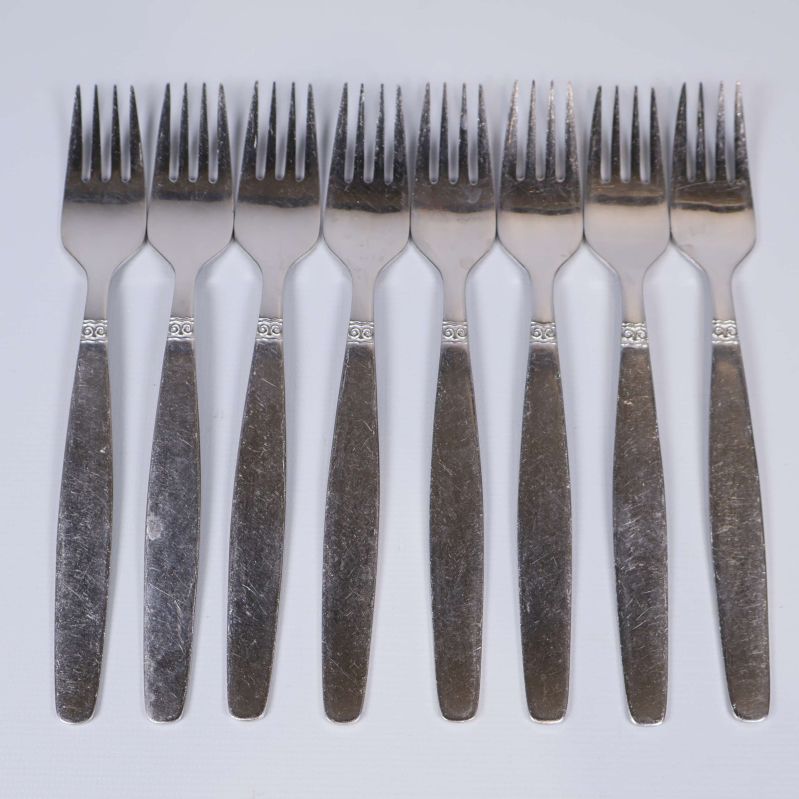 Åtta rostfria gafflar uppställda på rad