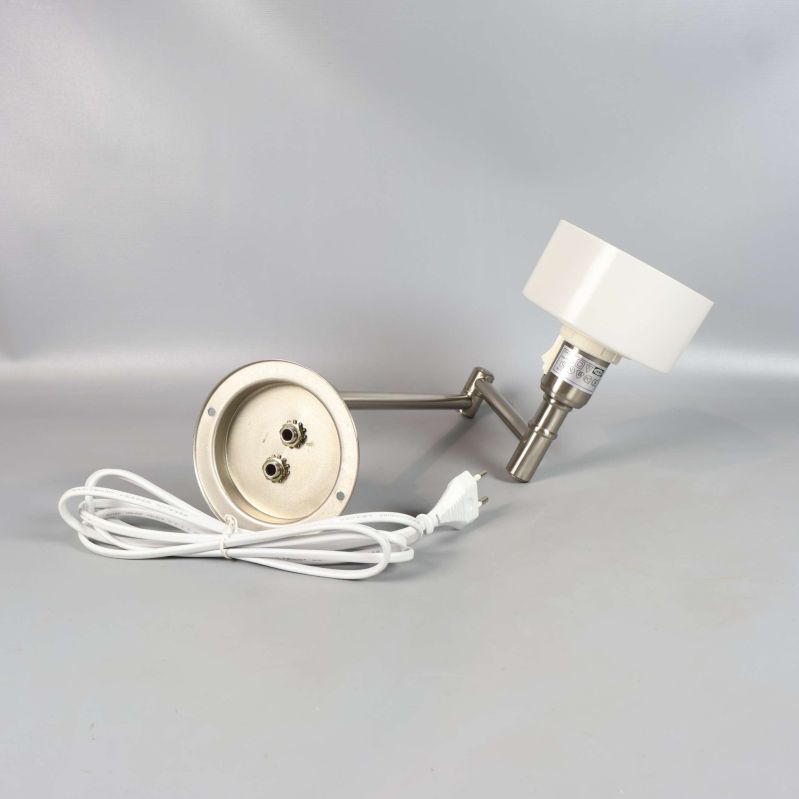 Vägglampans baksida och vit sladd syns mot grå bakgrund