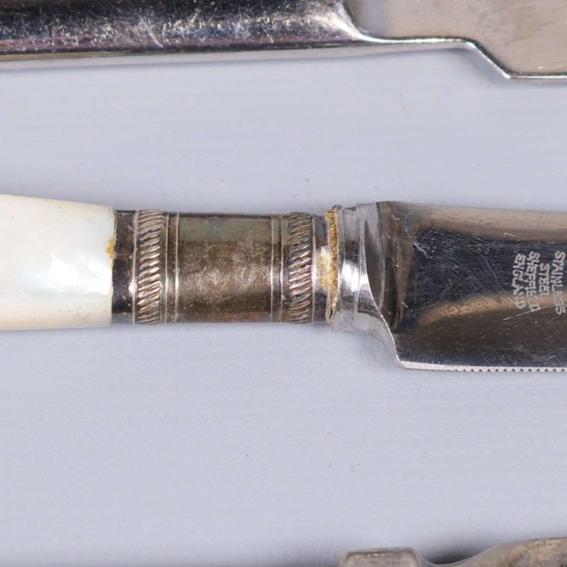 Närbild på ostkniv med pärlemorskimrande handtag