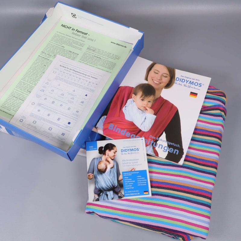 Öppen låda med bärsjal, broschyrer och instruktioner