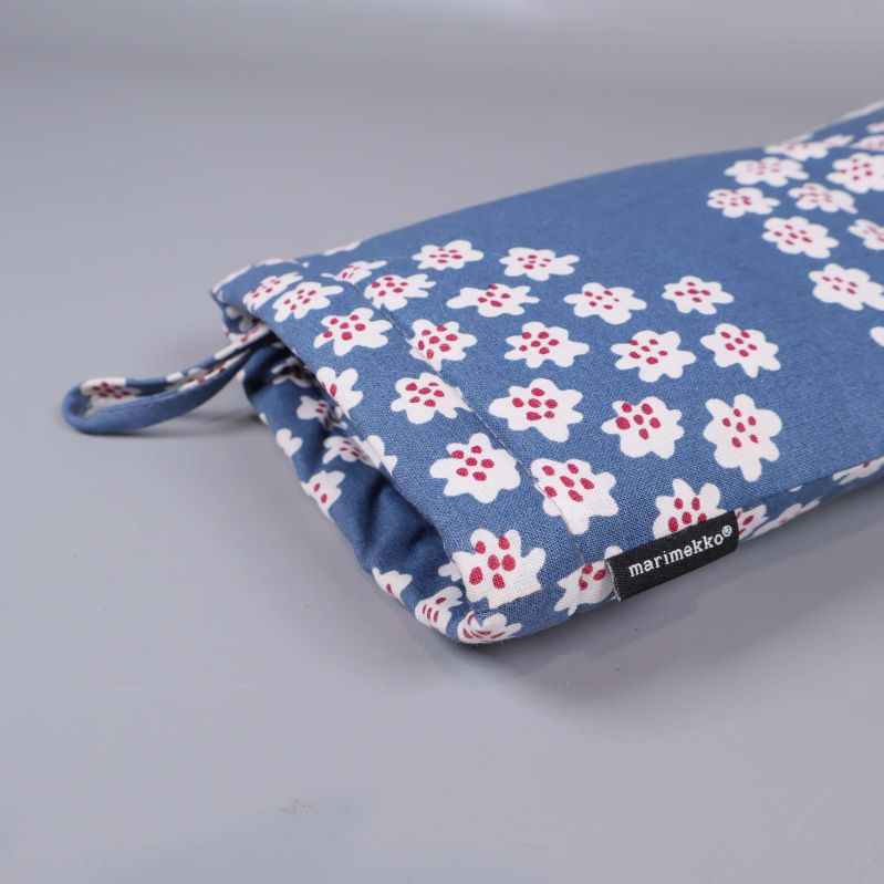 Närbild på grytvante och Marimekko-etikett på sidan