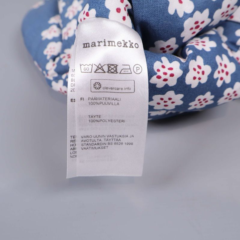 Tvättrådsetikett med Marimekko-logotyp visas inuti grytvanten