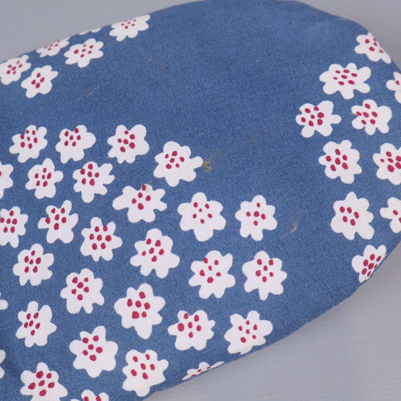 Närbild på grytvante i blått tyg med blommönster
