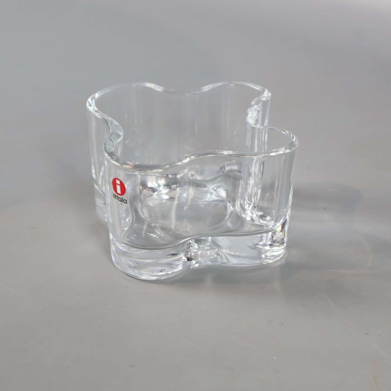 Klarglaslykta med vågig design mot ljus bakgrund