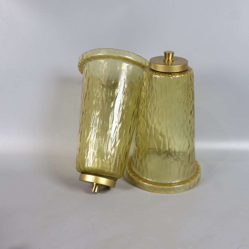 Två lösa lampskärmar av gultonat strukturerat glas liggandes