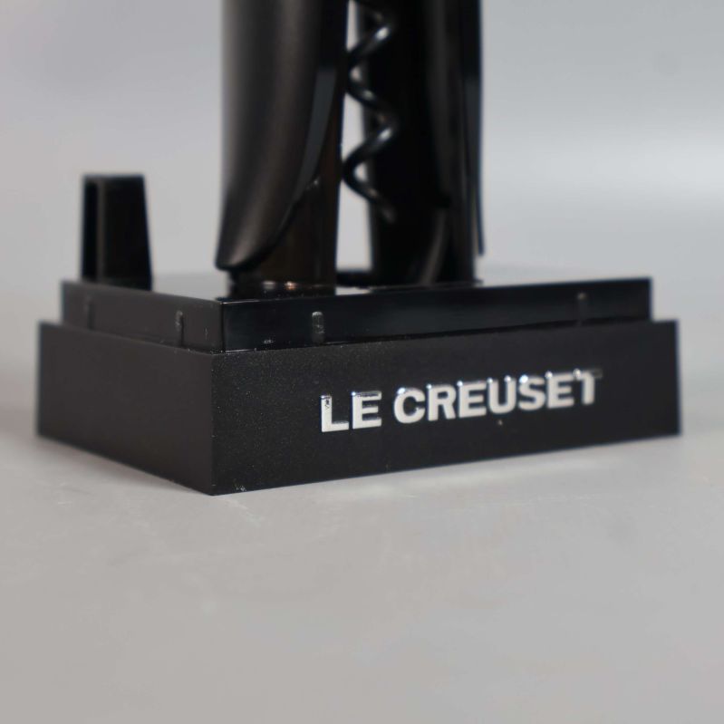 Närbild på Le Creuset-logotypen på korkskruvens ställ