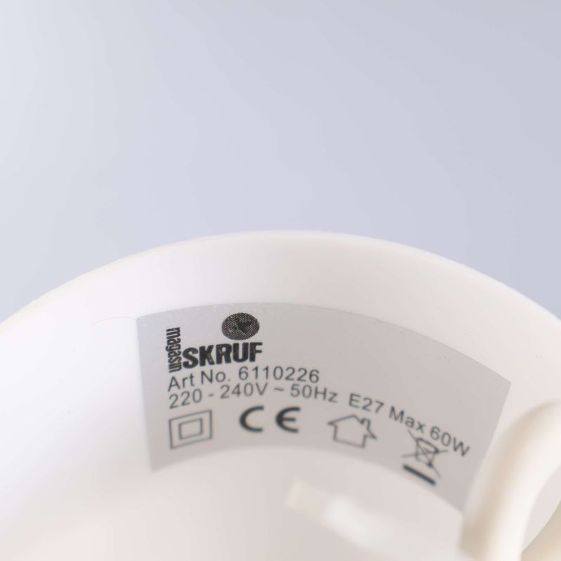 Vit märkning inuti lamphållare med SKRUF logotyp synlig