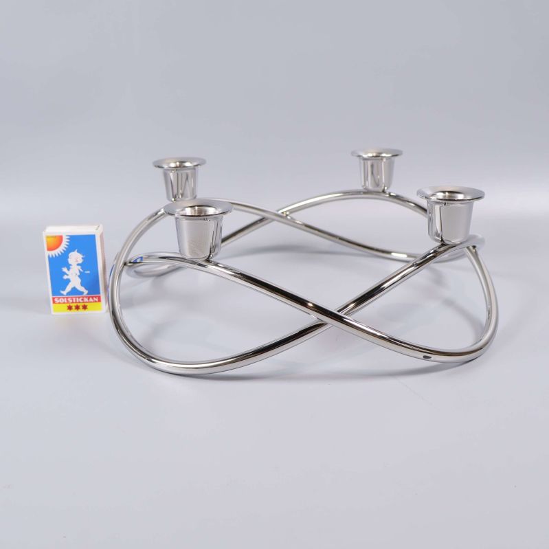 Ljusstake i blank metall bredvid tändsticksask