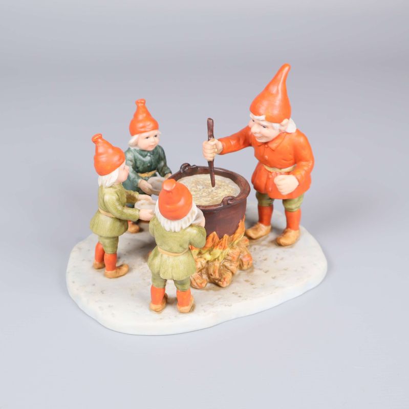 Tomtefigur med fyra nissar runt en gryta