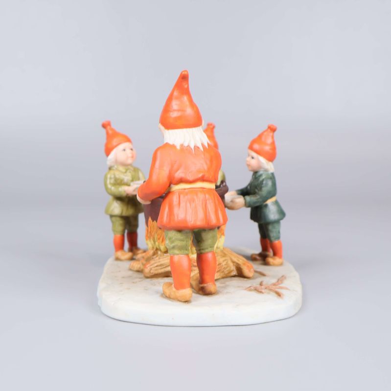 Tomtefigur sedd snett bakifrån med tre nissar synliga