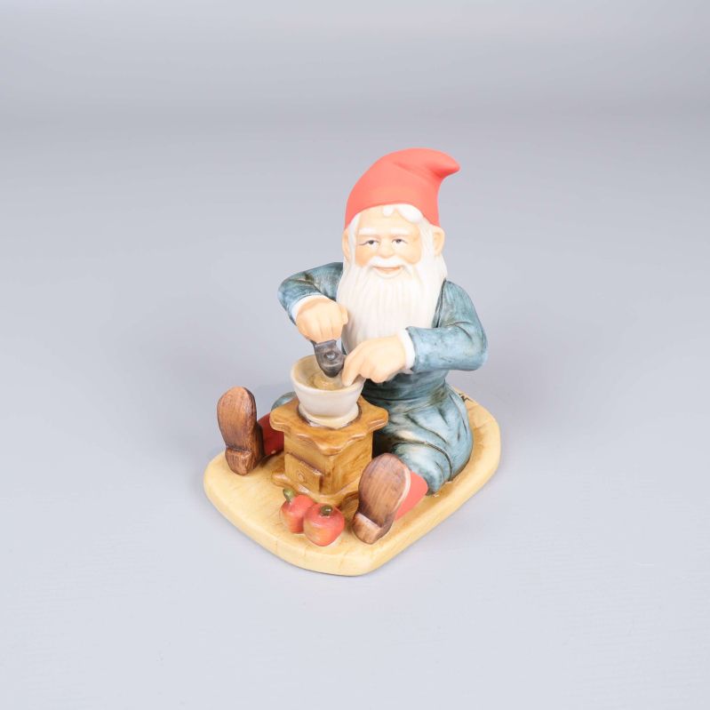Porslinsfigur av tomte som maler med en kvarn