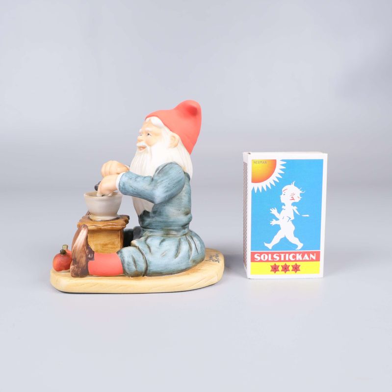 Tomtefigur bredvid en tändsticksask för storleksjämförelse