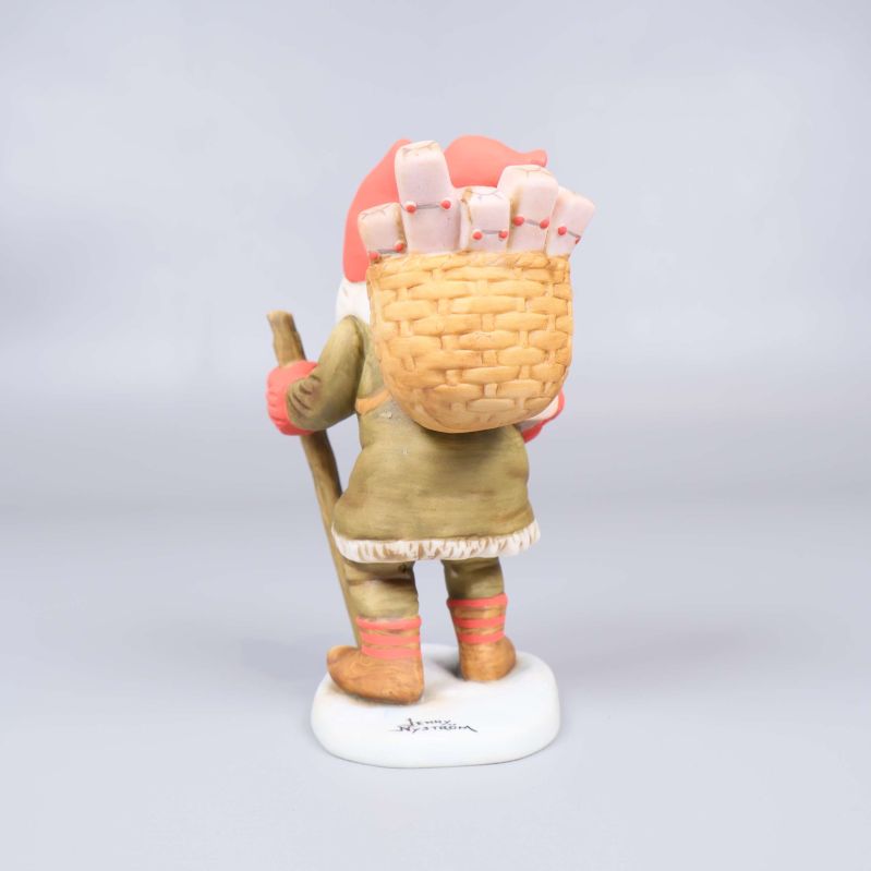 Tomtefigur bakifrån med synlig signatur på foten