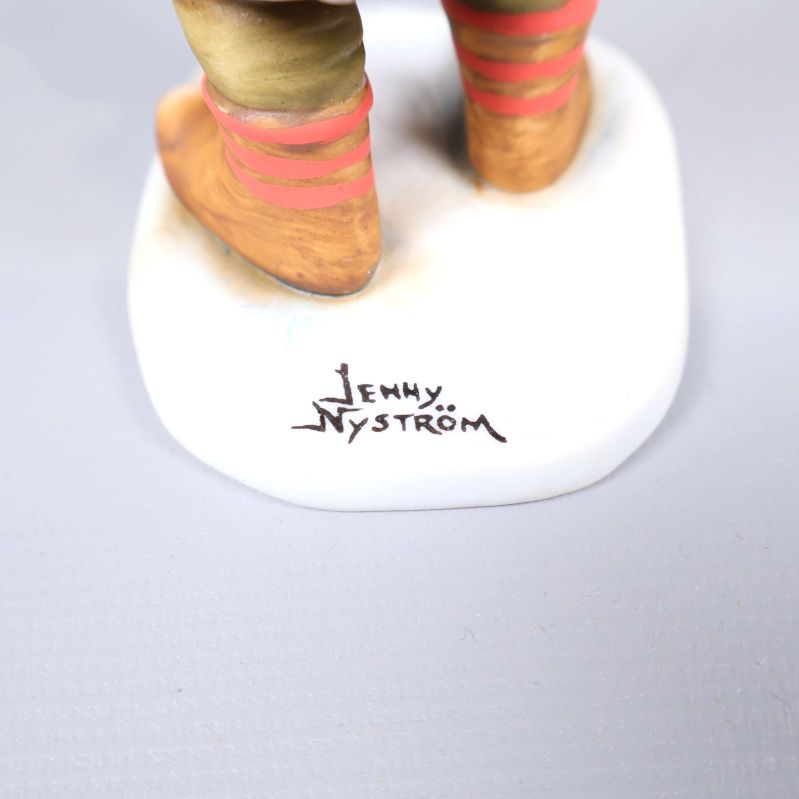 Närbild på signaturen Jenny Nyström på tomtefigurens bas