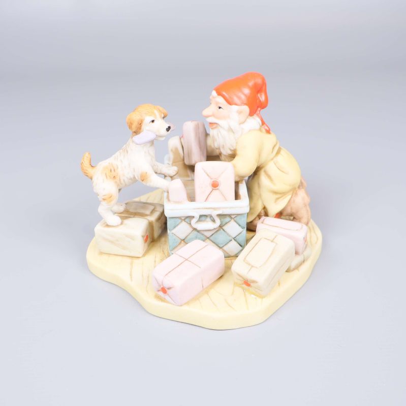 Porslinsfigur med tomte och hund samt paket