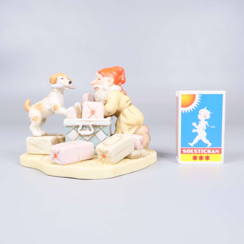 Porslinsfigur bredvid tändsticksask för storleksreferens