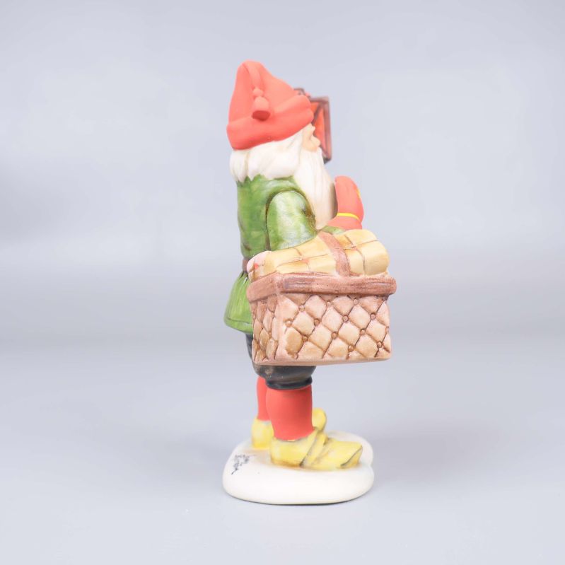 Närbild från sidan på tomtens korg och grön jacka