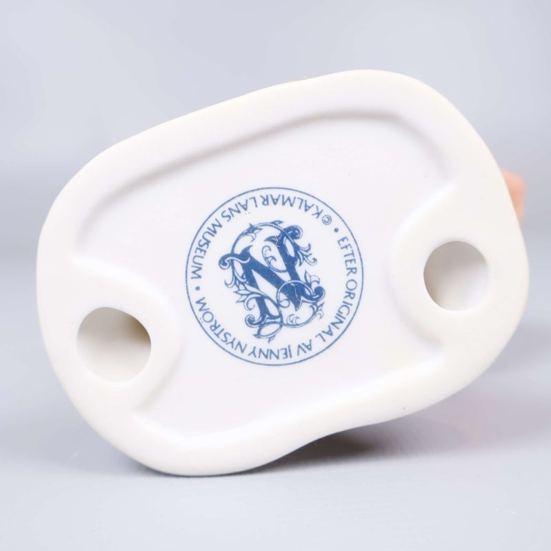 Stämpel under tomtefigur med Jenny Nyström och etiketttext