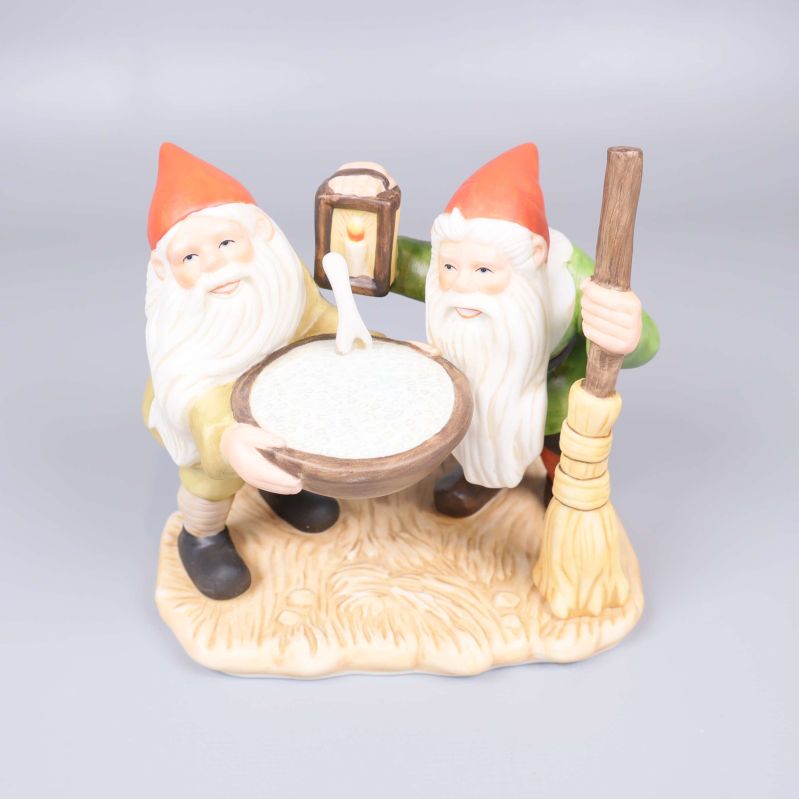 Två tomtar med gröt och kvast på dekorativ bas