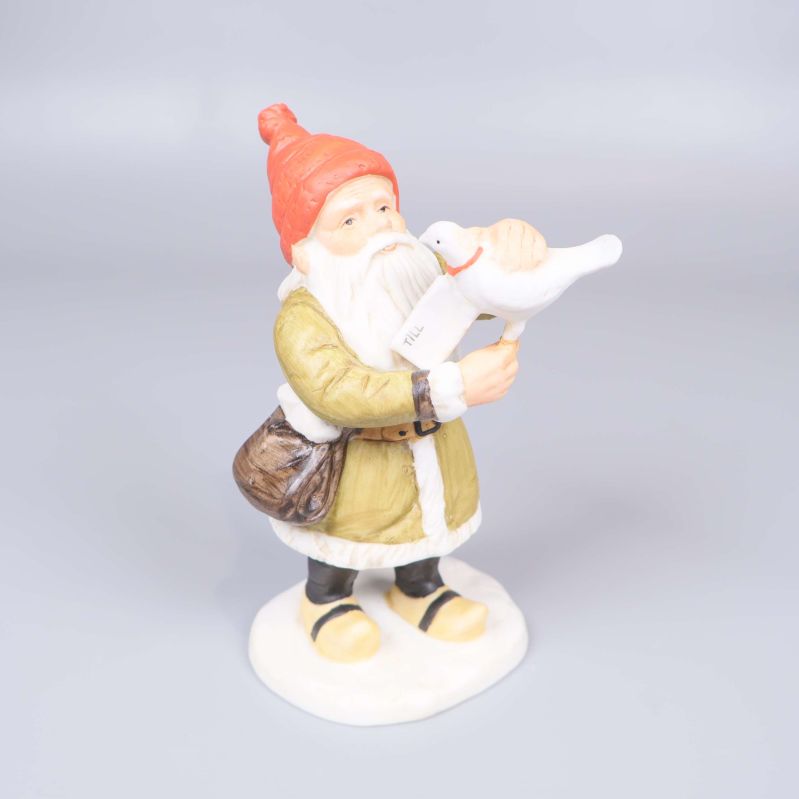 Tomtefigur med röd luva och vit duva på armen