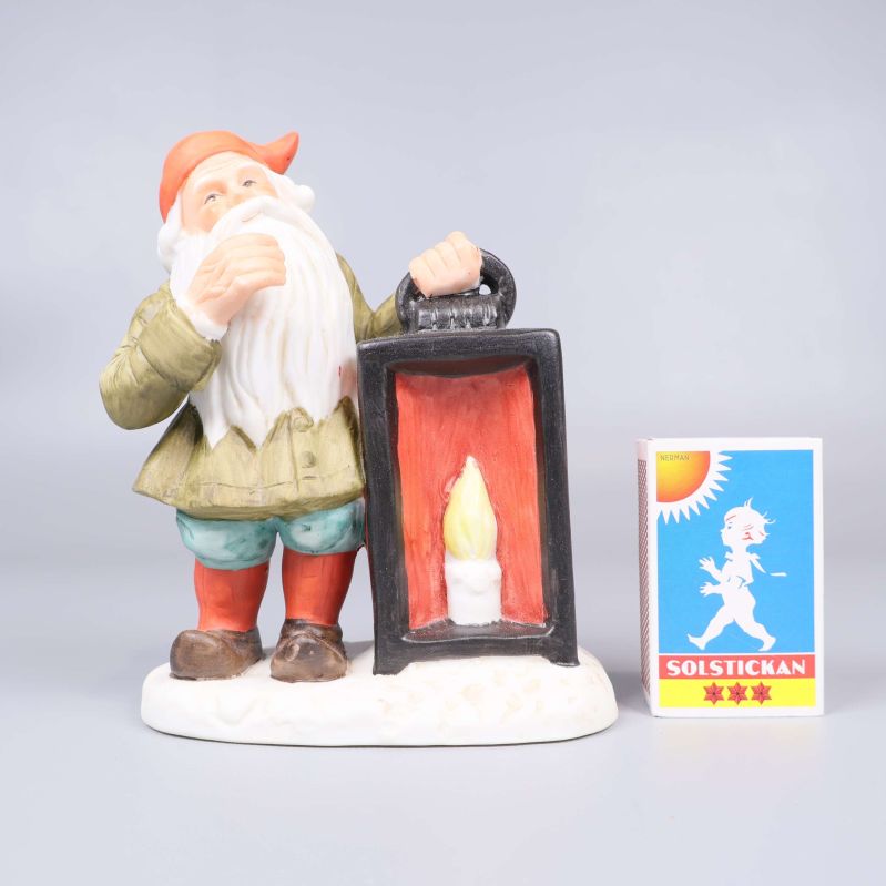 Tomtefigur med lykta och tändsticksask bredvid