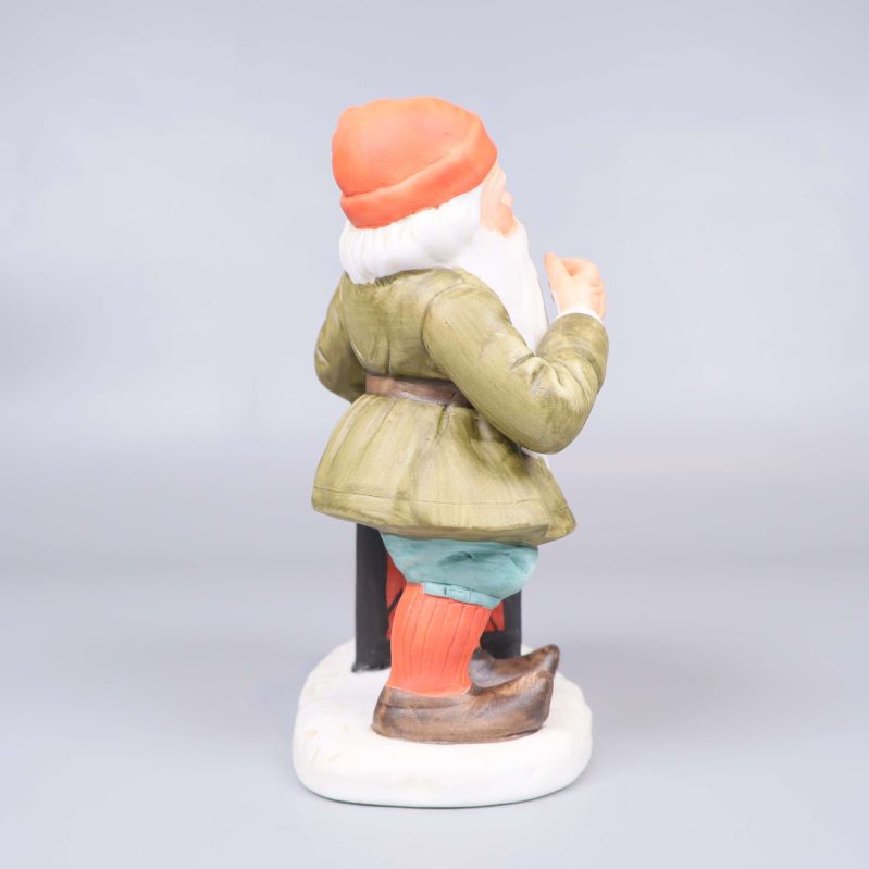 Tomtefigur i profil med grön jacka och lykta