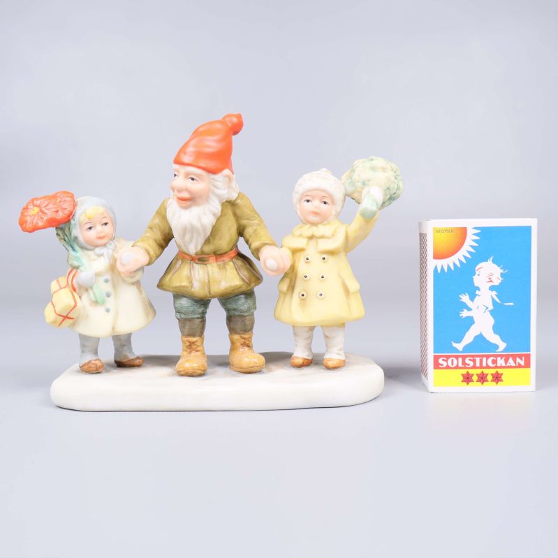 Tomtefigur med två barn och tändsticksask som storleksjämförelse