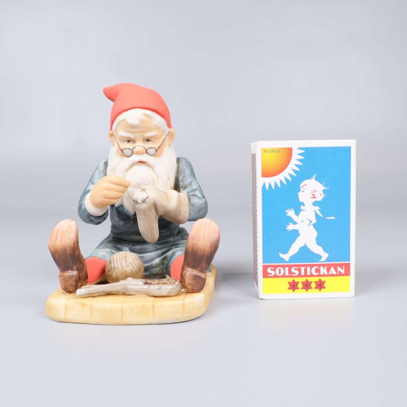 Tomtefigur bredvid tändsticksask för storleksjämförelse