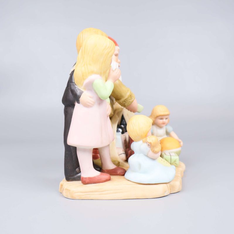 Sida av porslinsfigur med barn och tomte