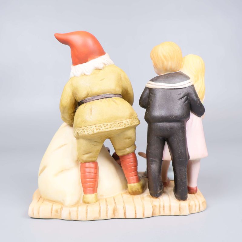 Baksida med detaljerad vy på barn och tomte i porslin