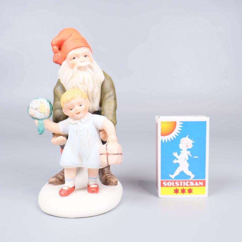 Porslinsfigur tomte och barn bredvid tändsticksask