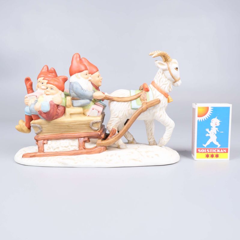 Tomtefigur i porslin bredvid tändsticksask för storleksjämförelse