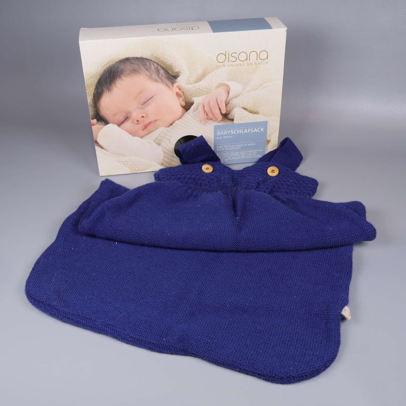 Marinblå stickad sovpåse med förpackning i bakgrunden