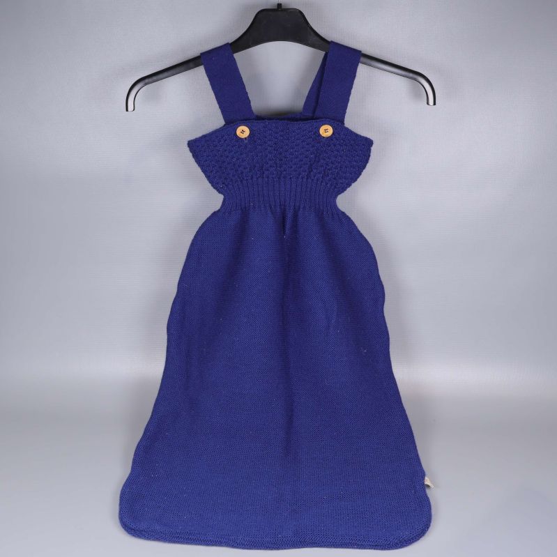 Stickad sovpåse med axelband upphängd på galge